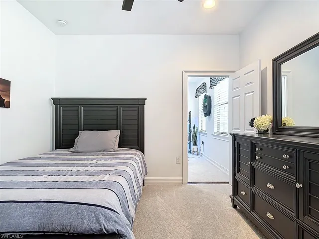 Carpeted bedroom featuring ceiling fan