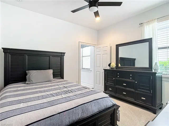 Bedroom with ceiling fan and light colored carpet