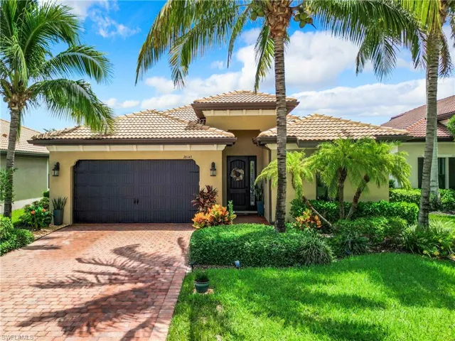 Mediterranean / spanish-style house with a garage and a front yard