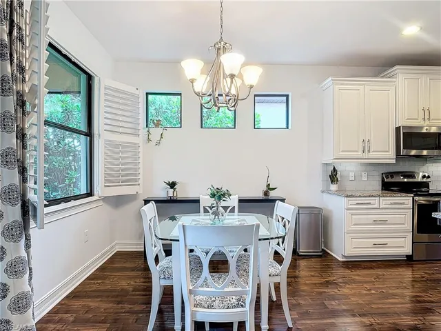 Dining room featuring dark hardwood / wood-style flooring and an inviting chandelier