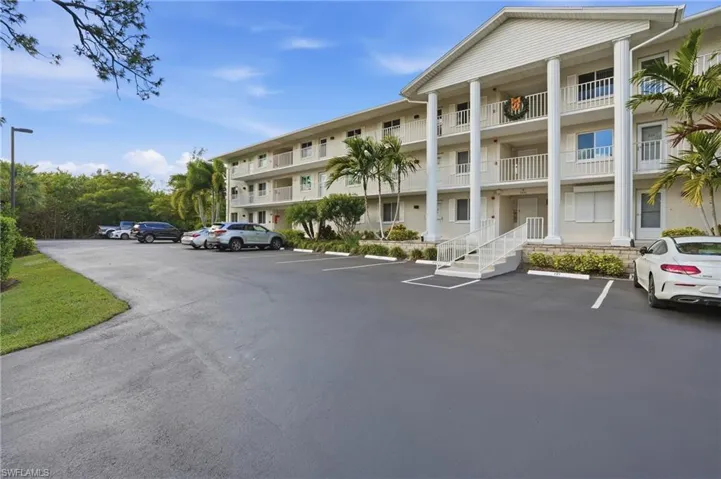 View of apartment building / complex with uncovered parking