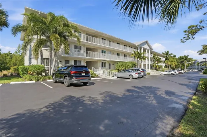View of apartment building / complex featuring uncovered parking