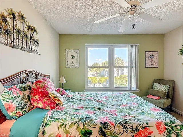 Bedroom with a textured ceiling and a ceiling fan