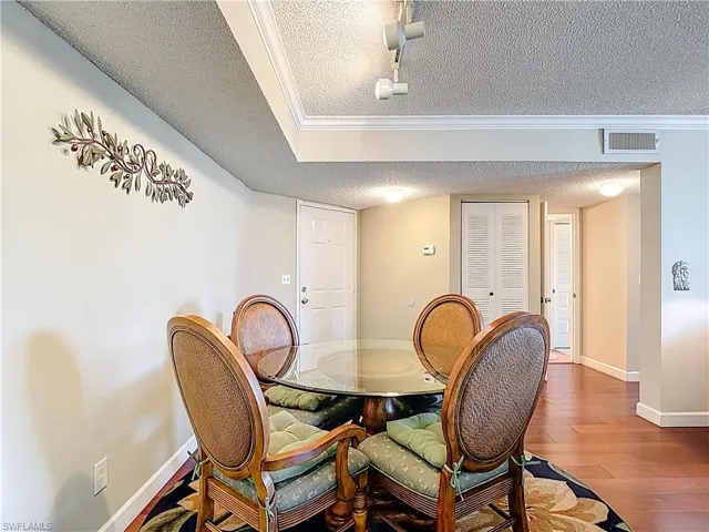 Dining space featuring a textured ceiling and hardwood / wood-style floors