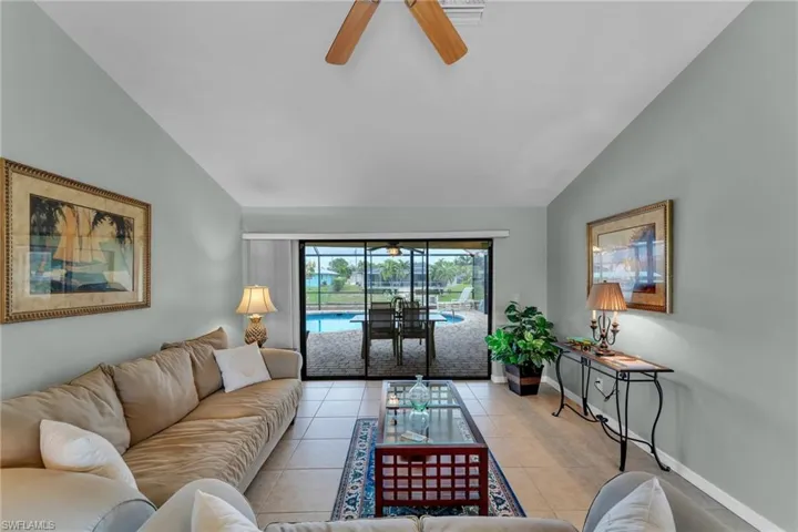 Tiled living room featuring ceiling fan and lofted ceiling