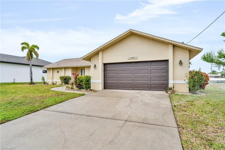 Ranch-style house with a front yard and a garage