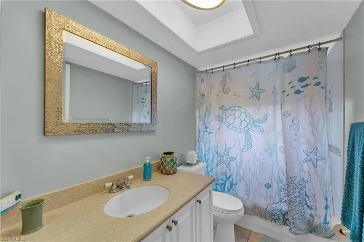 Full bathroom featuring toilet, vanity, shower / tub combo, and tile patterned floors