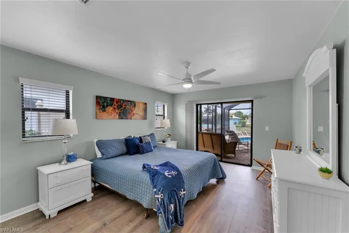Bedroom with ceiling fan, hardwood / wood-style floors, and access to outside