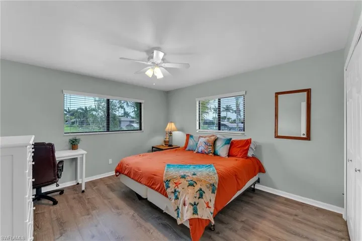 Bedroom with ceiling fan, a closet, and multiple windows