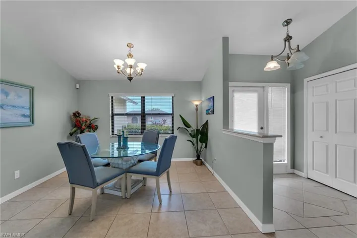 Dining room with light tile patterned flooring and a chandelier