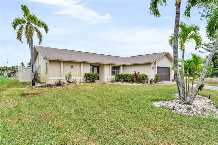Ranch-style home with a front lawn and a garage