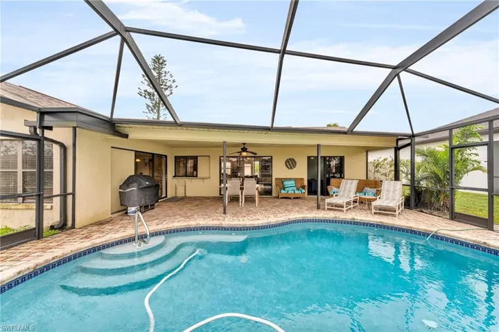 View of swimming pool featuring ceiling fan, a lanai, and a patio