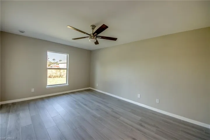 Empty room with wood finish floors and ceiling fan