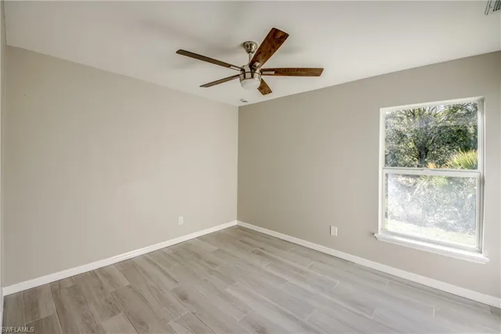 Empty room featuring wood tiled floors and a ceiling fan