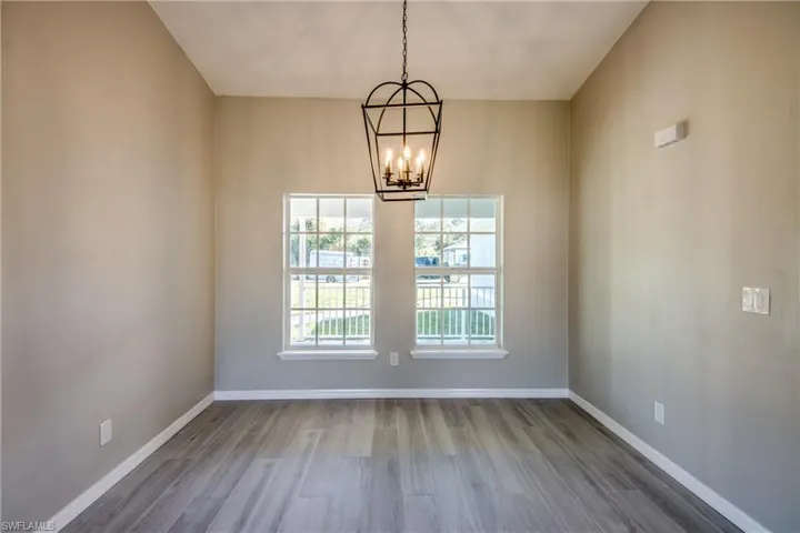 Unfurnished dining area featuring light wood finished floors and a chandelier