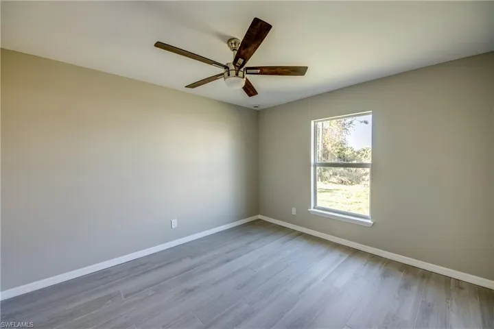 Spare room with light wood finished floors and a ceiling fan