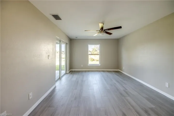 Empty room with light wood finished floors and a ceiling fan