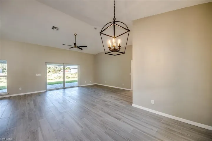 Spare room featuring light wood-type flooring, a chandelier, and ceiling fan