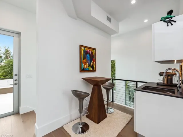 Bar with hardwood / wood-style flooring and sink