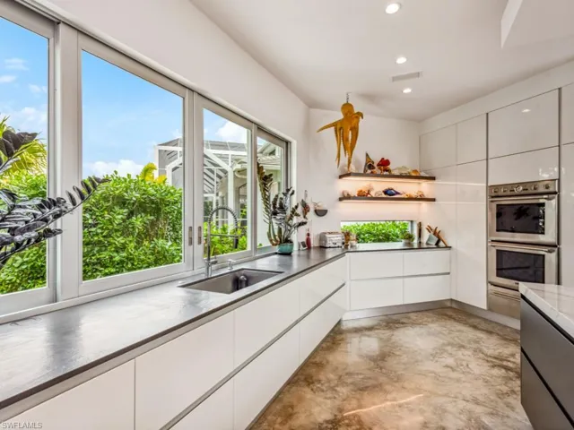 Kitchen featuring double oven, sink, and white cabinets