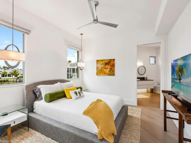 Bedroom with connected bathroom, light hardwood / wood-style flooring, and ceiling fan