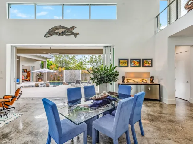 Dining area with a high ceiling, a healthy amount of sunlight, and concrete floors