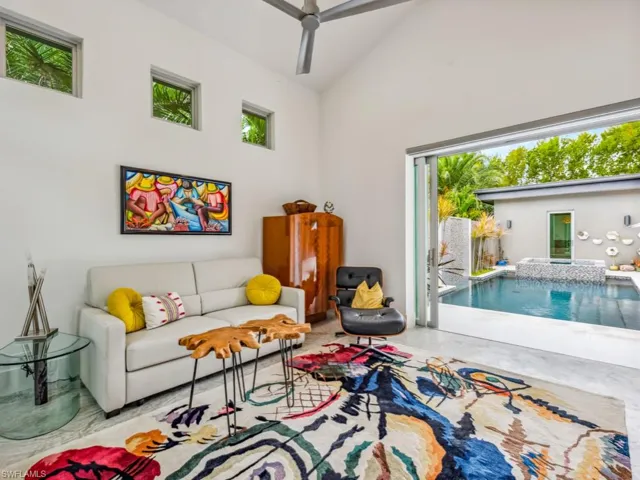 Living room featuring high vaulted ceiling and ceiling fan