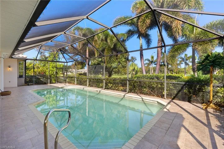 View of pool with a patio and glass enclosure