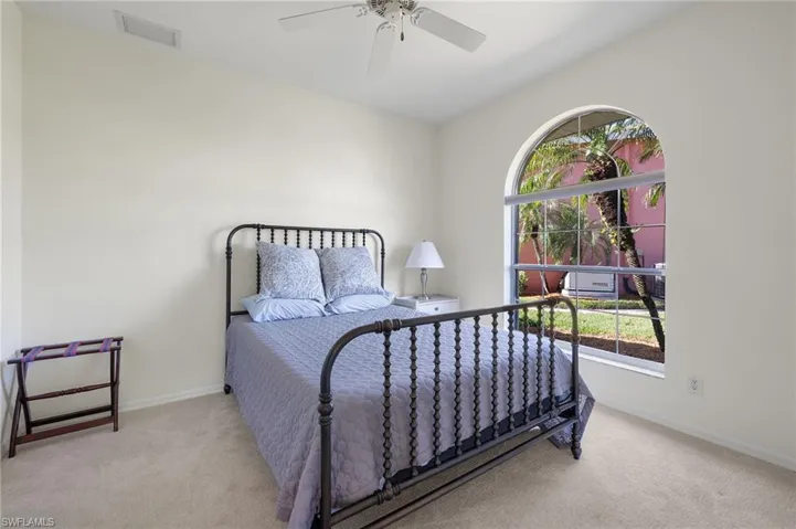 Bedroom with ceiling fan and light carpet
