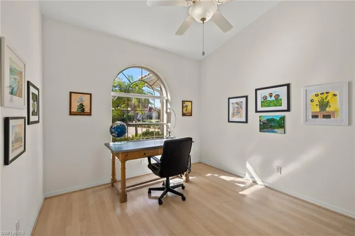 Office space featuring ceiling fan, light hardwood / wood-style flooring, and vaulted ceiling