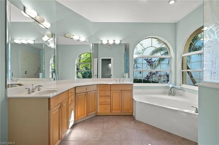 Bathroom featuring vanity, tile patterned floors, a bathtub, and ceiling fan