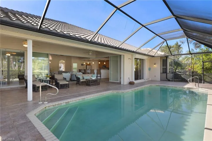 View of pool with a lanai, an outdoor hangout area, ceiling fan, and a patio area