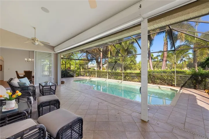 View of pool with outdoor lounge area, ceiling fan, a patio area, and glass enclosure