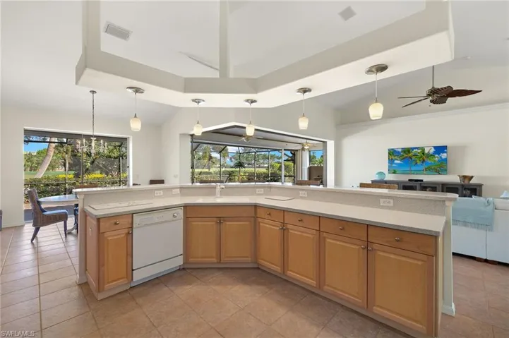 Kitchen with dishwasher, ceiling fan, lofted ceiling, and decorative light fixtures