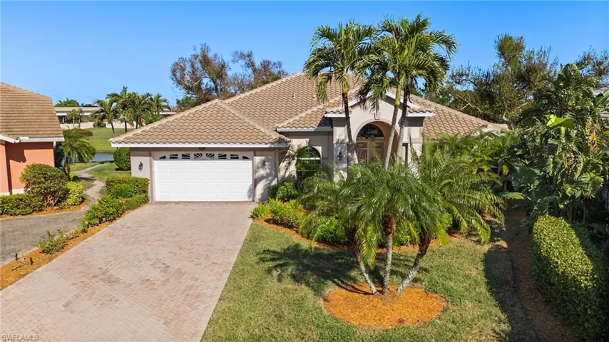 Mediterranean / spanish-style home featuring a garage and a front lawn