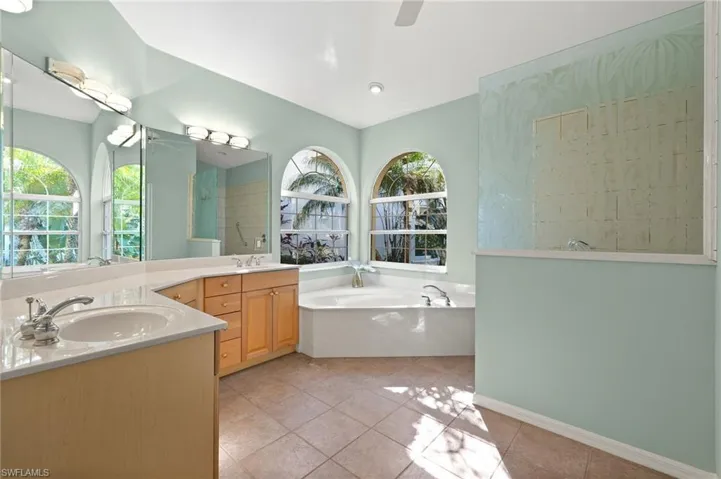 Bathroom with tile patterned flooring, vanity, and independent shower and bath