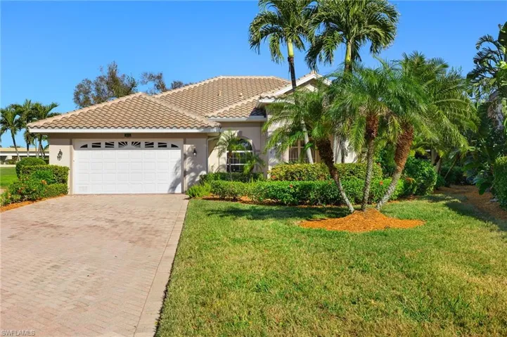 Mediterranean / spanish-style house with a front lawn and a garage