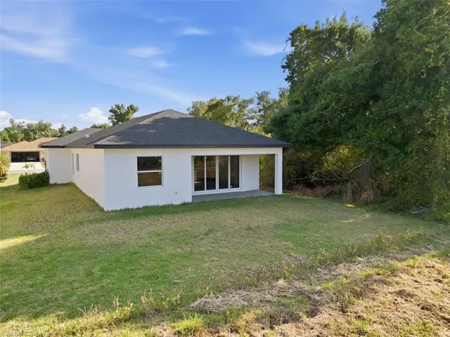 Contemporary exterior with a dark shingle roof and white stucco finish