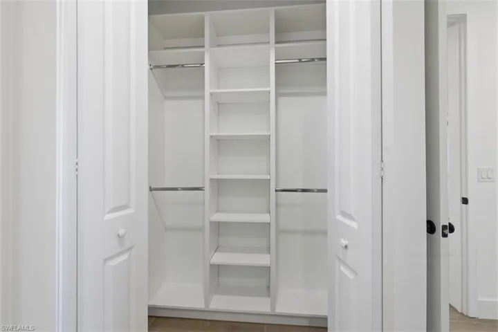 Custom closet system with integrated shelving and chrome hanging rods