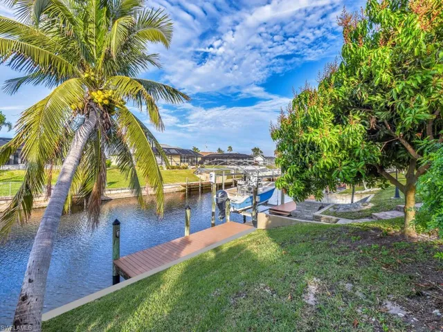 Dock area with a water view and a yard