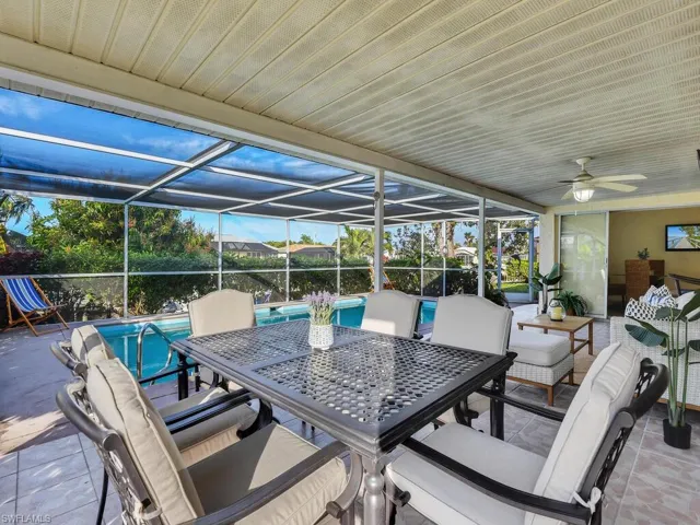 View of patio with ceiling fan and glass enclosure
