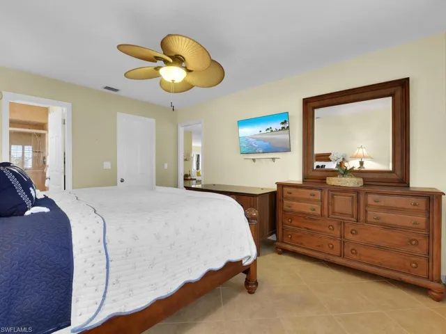 Tiled bedroom featuring ceiling fan