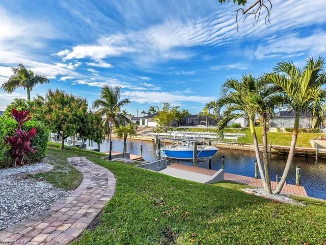 View of dock featuring a lawn and a water view