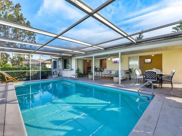 View of pool with a lanai, outdoor lounge area, and a patio