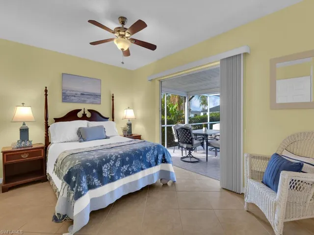 Tiled bedroom featuring ceiling fan and access to exterior