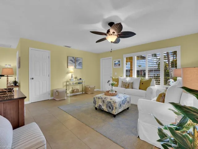 Living room with ceiling fan and light tile patterned floors