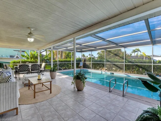 View of pool featuring a lanai, ceiling fan, and a patio area