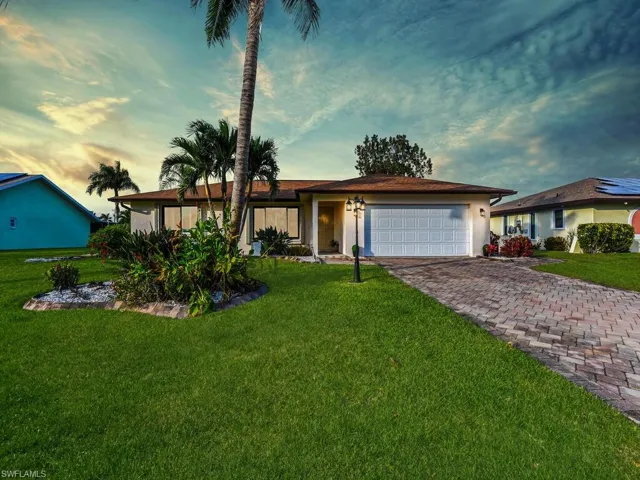 Ranch-style home featuring a lawn and a garage