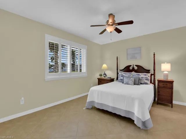 Tiled bedroom featuring ceiling fan