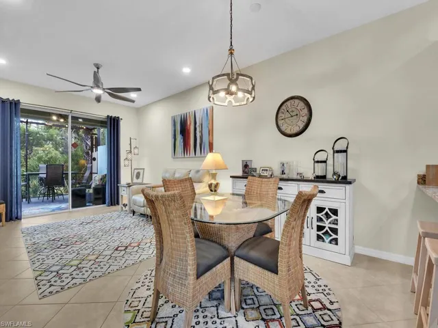 Tiled dining space with ceiling fan with notable chandelier